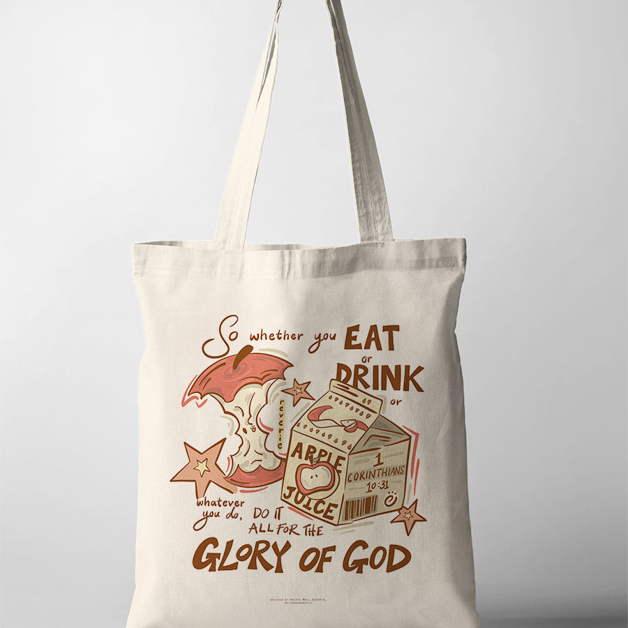 Canvas Christian tote bag with playful apple and juice illustration and the verse “Do it all for the glory of God” from 1 Corinthians 10:31