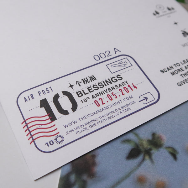 A postcard commemorating the "10 Blessings" 10th anniversary, with an air post stamp dated 02.05.2014, promoting the message "Join us in making the world a brighter place, one postcard at a time.