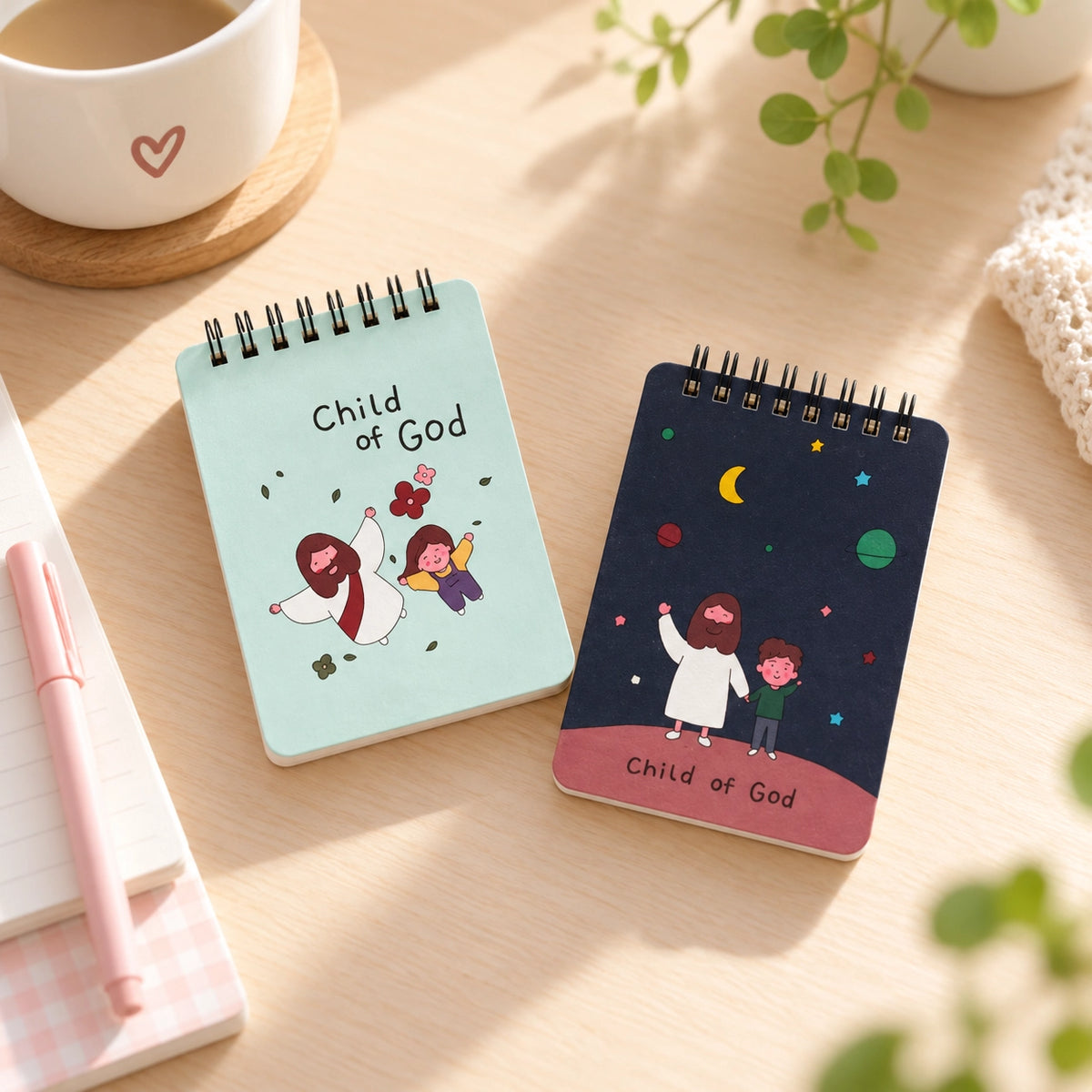 Child of God Christian spiral notepads in flower and universe designs on a bright desk