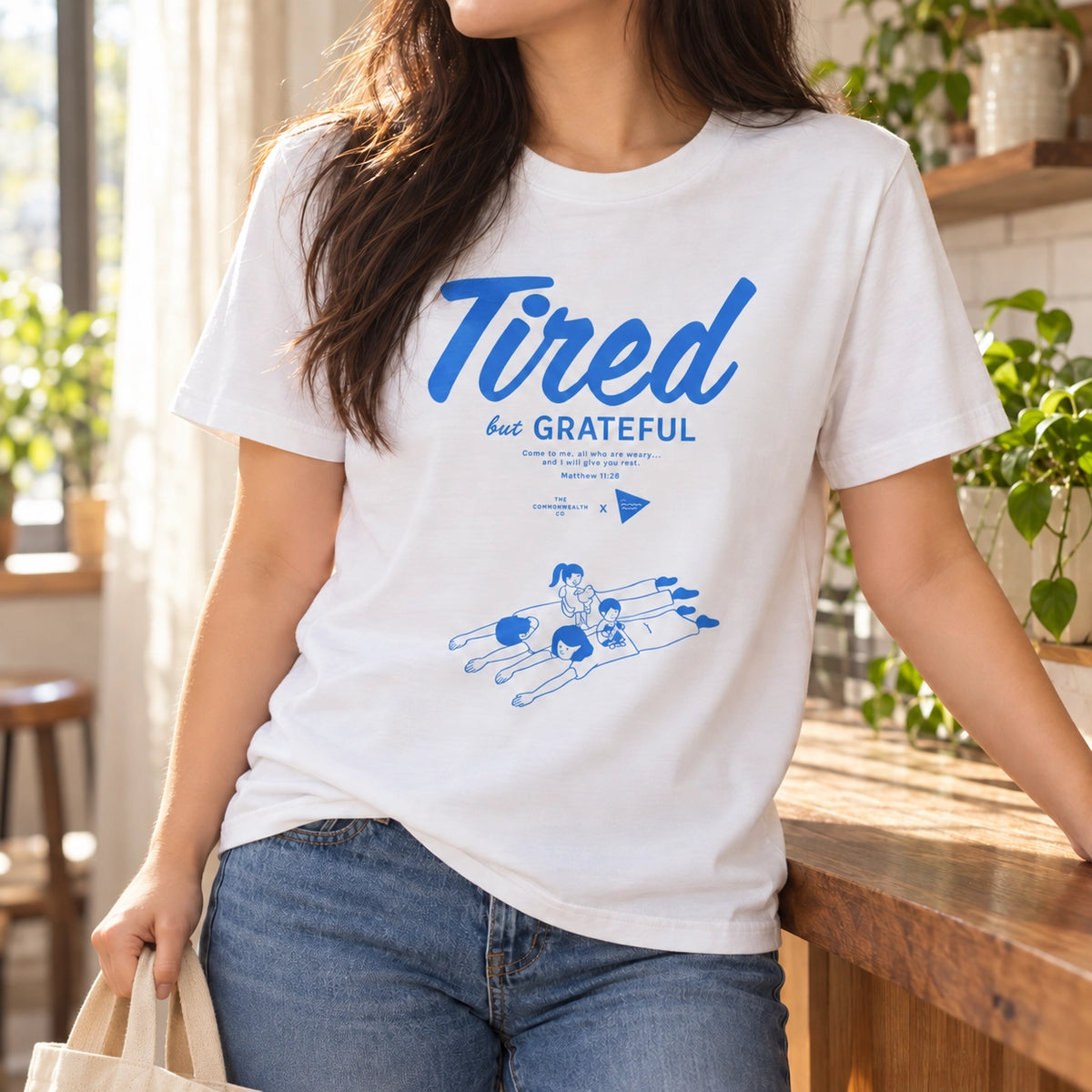Tired But Grateful Christian white T-shirt worn in a warm sunlit kitchen