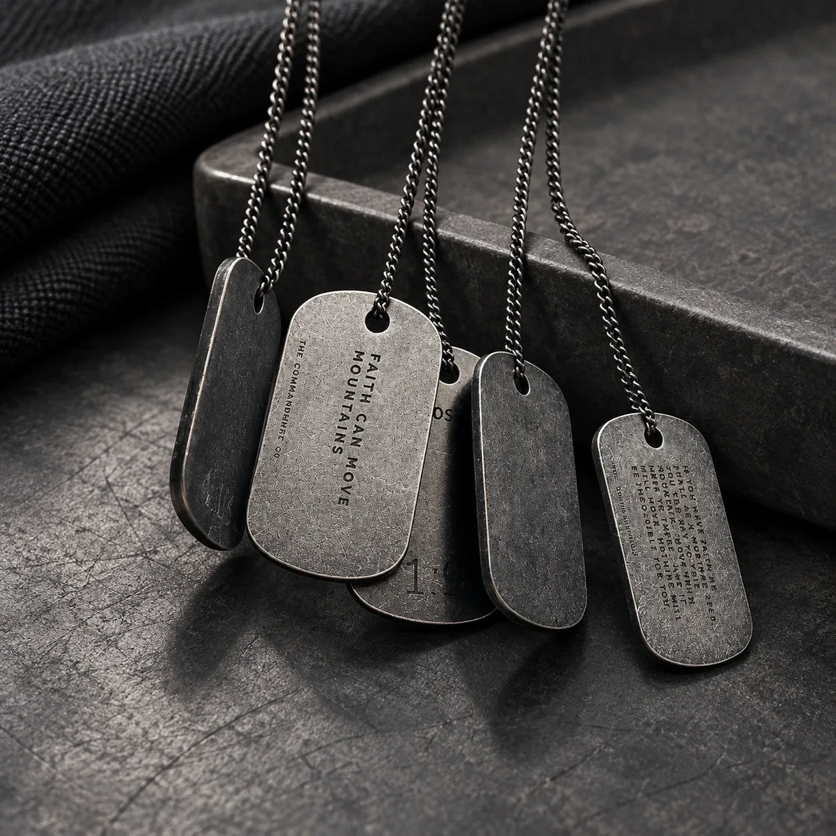 Gunmetal dog tag necklaces featuring Faith Can Move Mountains engraving in a dark minimalist jewellery setting
