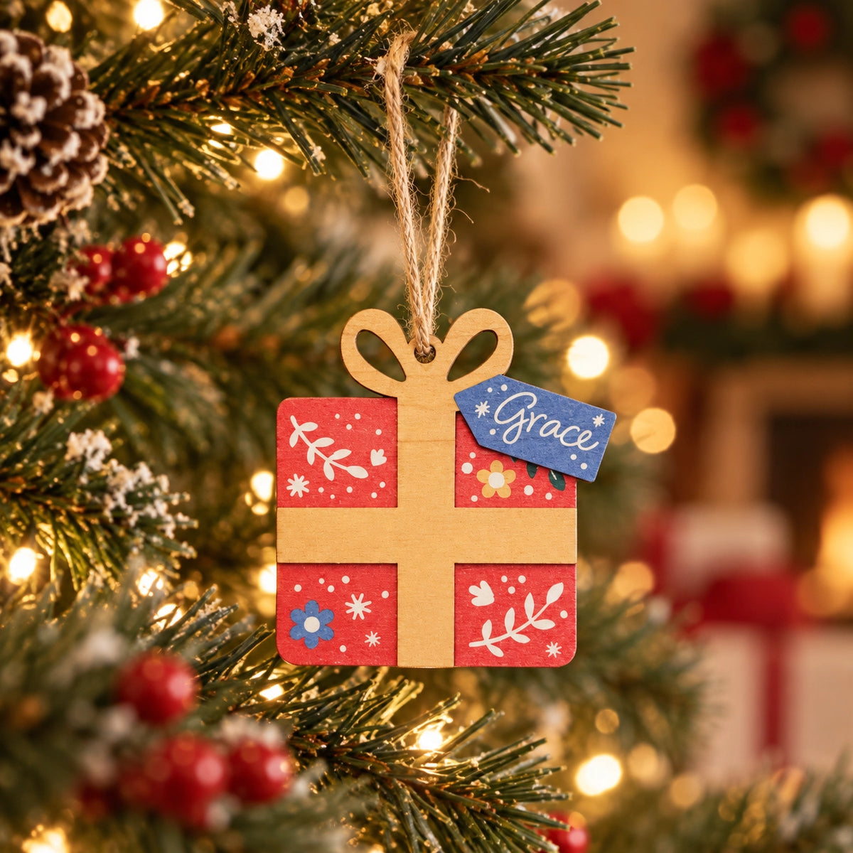 Grace Christmas tree bauble hanging from a lit Christmas tree in a cosy home