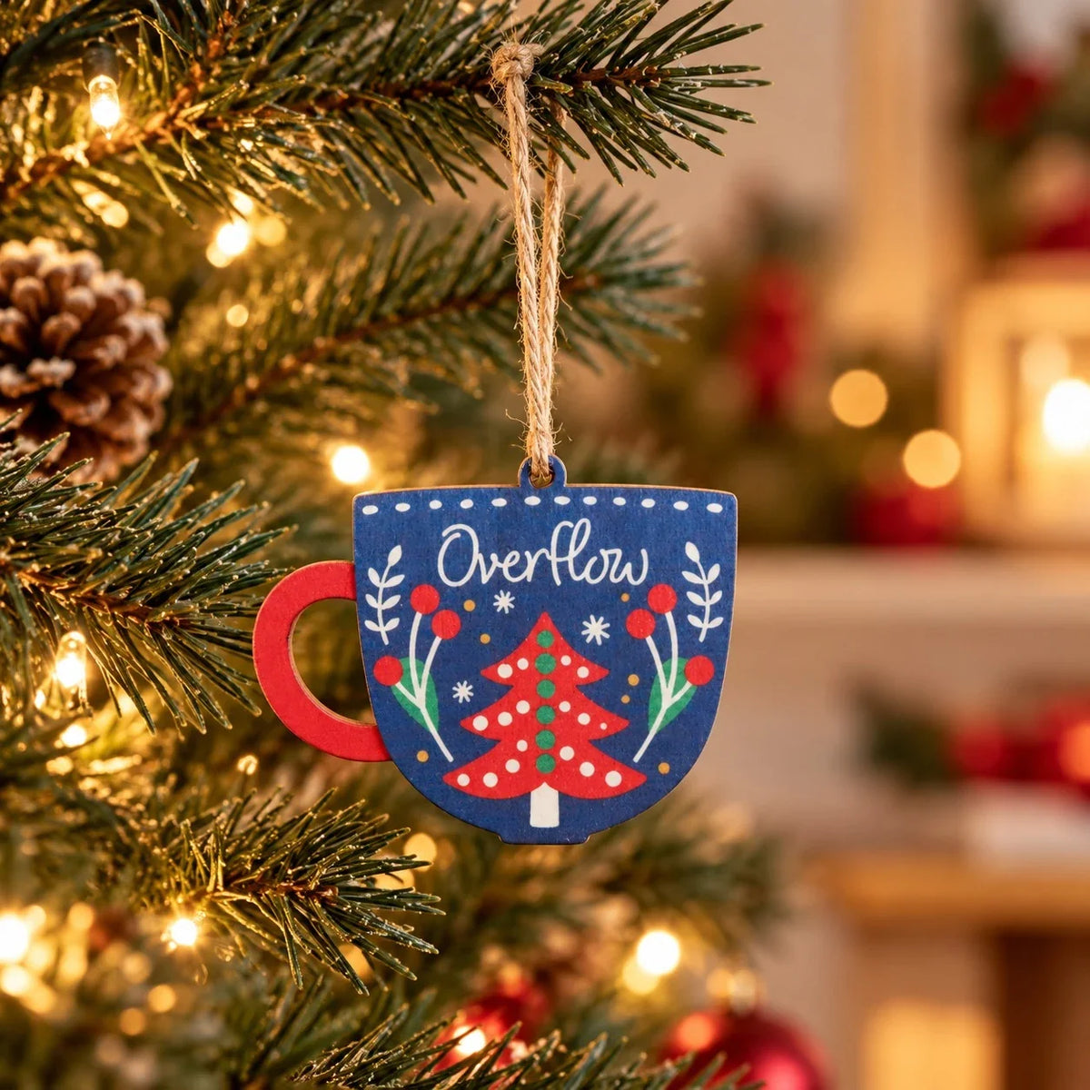 Overflow cup-shaped wooden Christmas tree bauble hanging on a festive tree
