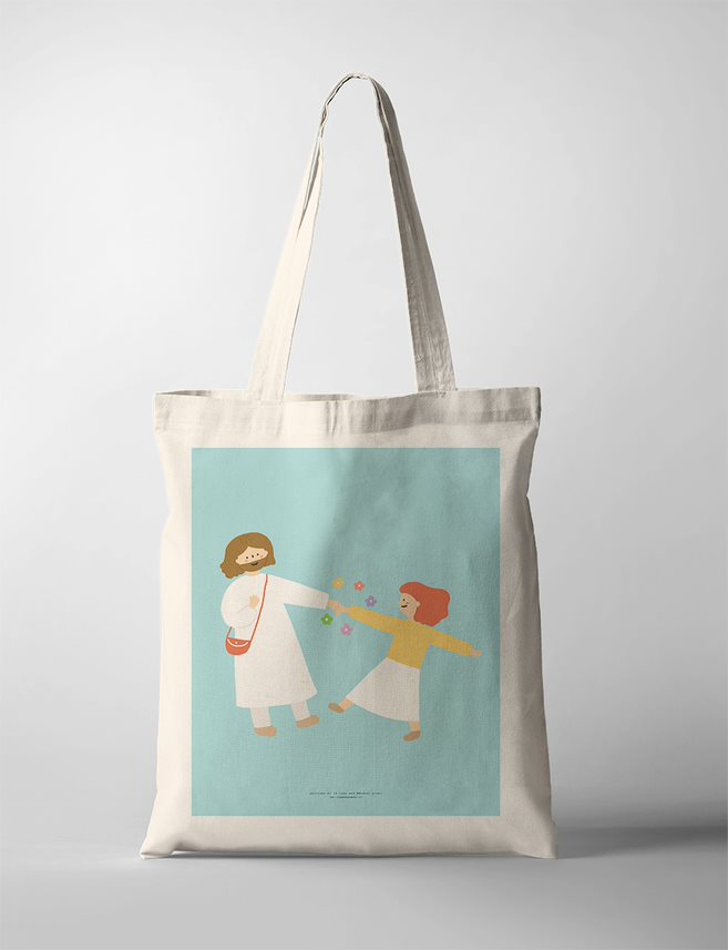 Faith based Tote Bag featuring a minimalist illustration of two figures, Jesus and a girl dancing set against a soft blue background. The design exudes a sense of peace and spirituality, encapsulated in a simple tote bag.