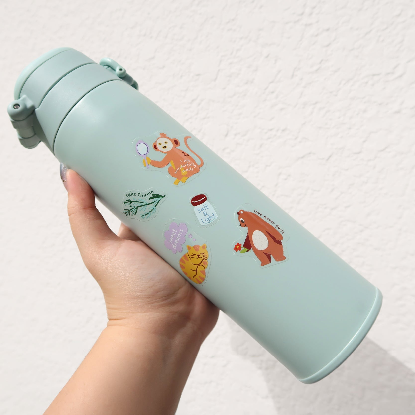 Reusable water bottle decorated with everyday believer Christian stickers, showing cute faith-inspired designs perfect for travel and daily use