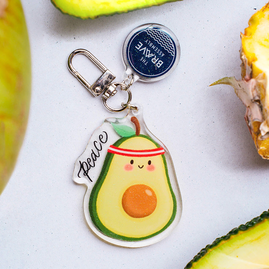 Avocado-shaped Peace acrylic keychain charm by The Brave Assembly.