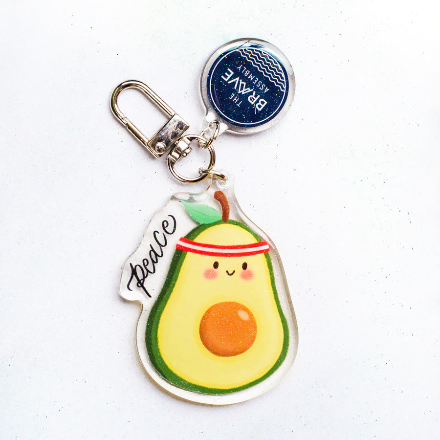 Peace Avocado v2 glitter-epoxy acrylic keychain by The Brave Assembly, product view.