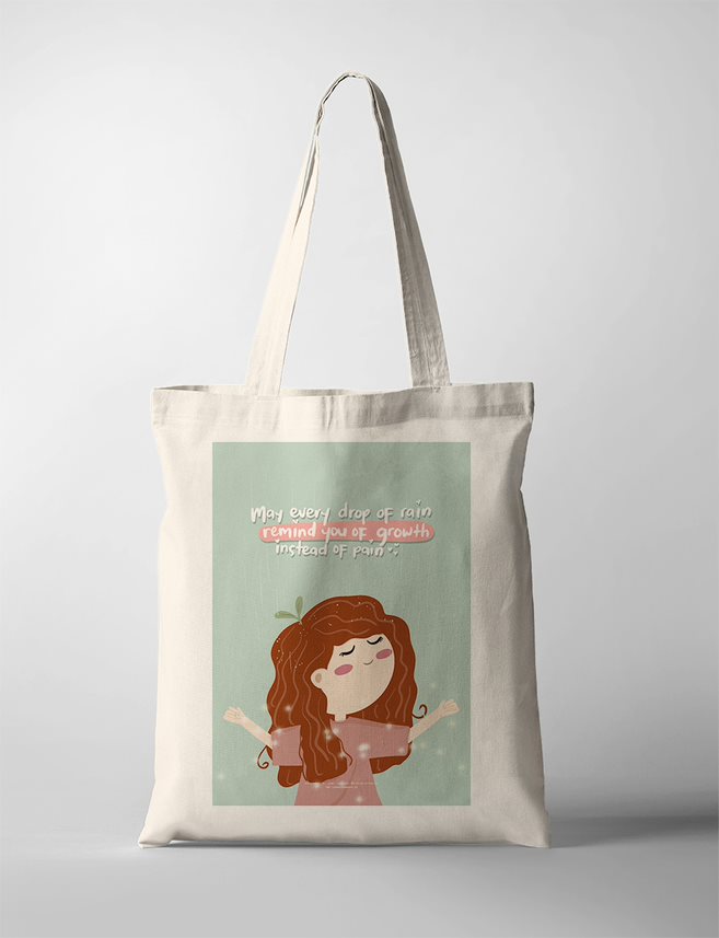 Faith based tote bag with an illustration of a serene girl with long curly brown hair, arms open wide as gentle rain falls on her. A small green sprout grows from her head, symbolizing growth through trials. Set against a soft teal background, the inspirational Christian quote says, “May every drop of rain remind you of growth instead of pain.” A comforting and hopeful piece of wall decor for believers.