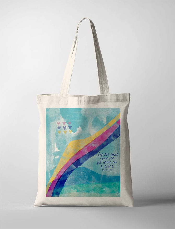 Christian faith tote bag with colorful abstract rainbow and hearts, featuring the Bible verse 'Let all that you do be done in love' from 1 Corinthians 16:14. Inspirational Christian tote bag.