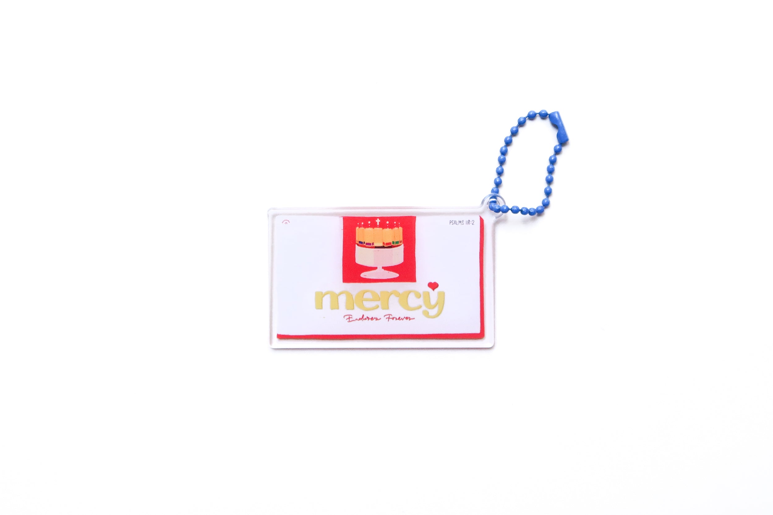 Mercy Endures Forever acrylic keychain with chocolate strips illustration and blue beaded chain on white background.