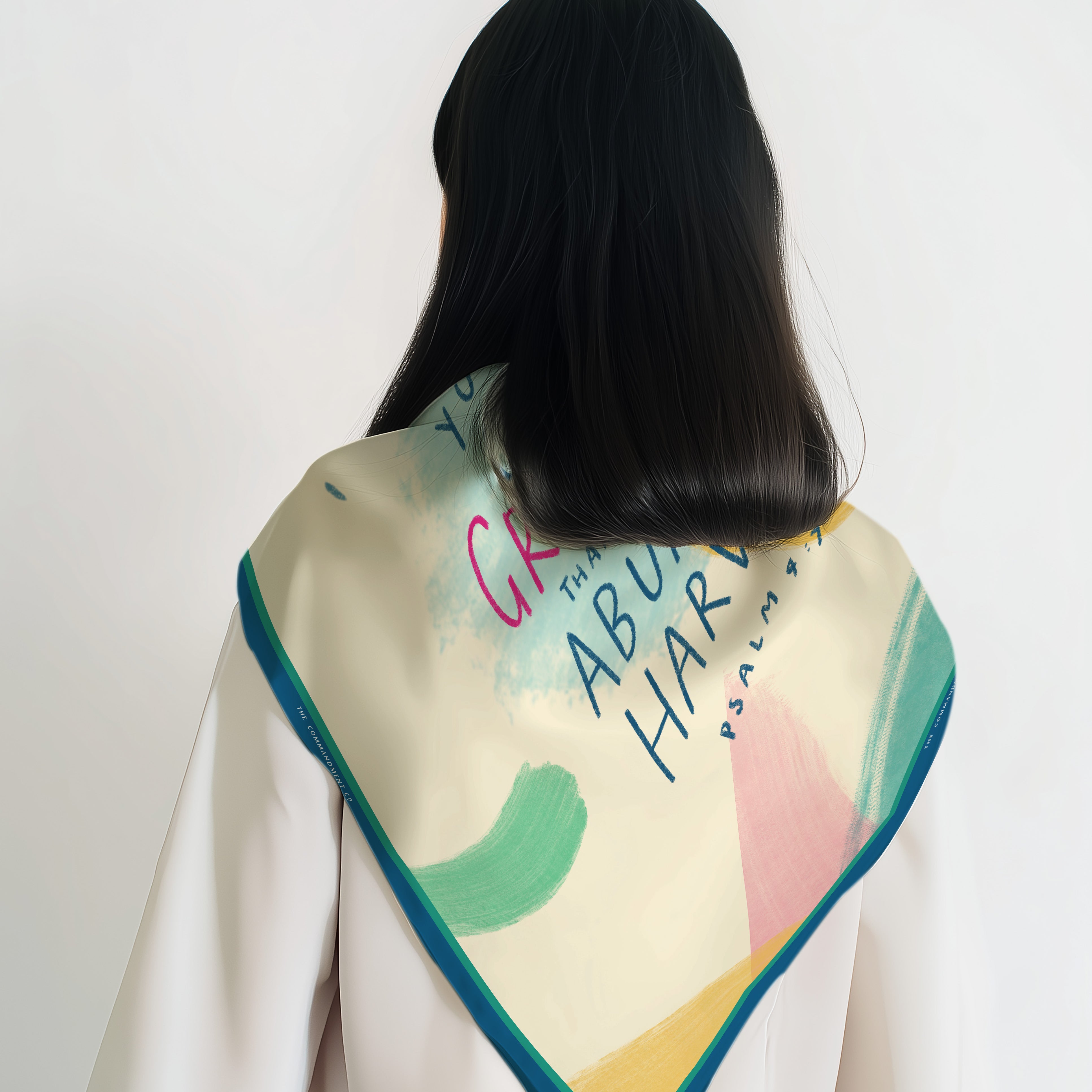 Abstract pastel scarf with teal border worn over a white top, shown from the back with colorful brushstrokes and script typography – a faith-forward accessory by The Commandment Co.