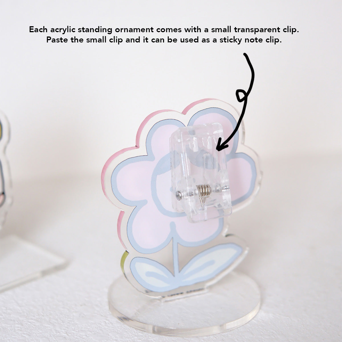 Back view of an acrylic standing ornament featuring a small transparent clip for use as a sticky note holder, showcasing multifunctional design.
