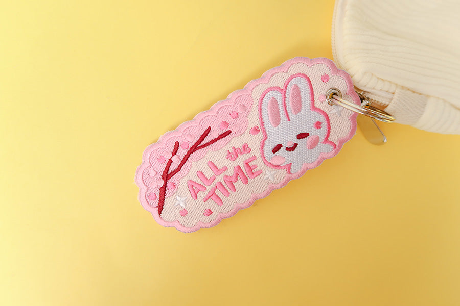 Adorable pink keychain featuring a cheerful white bunny and the words 'ALL the TIME'.