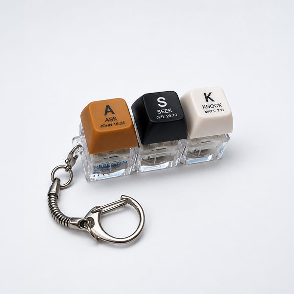 ASK SEEK KNOCK light-up keycap keychain with three coloured keys and silver clasp on a white background