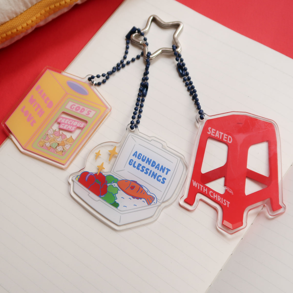 Set of three acrylic keychains featuring "Baked with Love," "Abundant Blessings," and "Seated with Christ" designs, from The Commandment Co, Singapore.