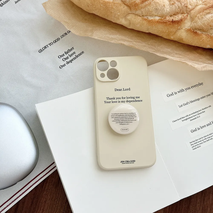 Cream-colored phone with a "Be anxious for nothing" pop socket featuring Philippians 4:6, surrounded by inspirational Christian stationery and fresh bread, encouraging faith and peace.