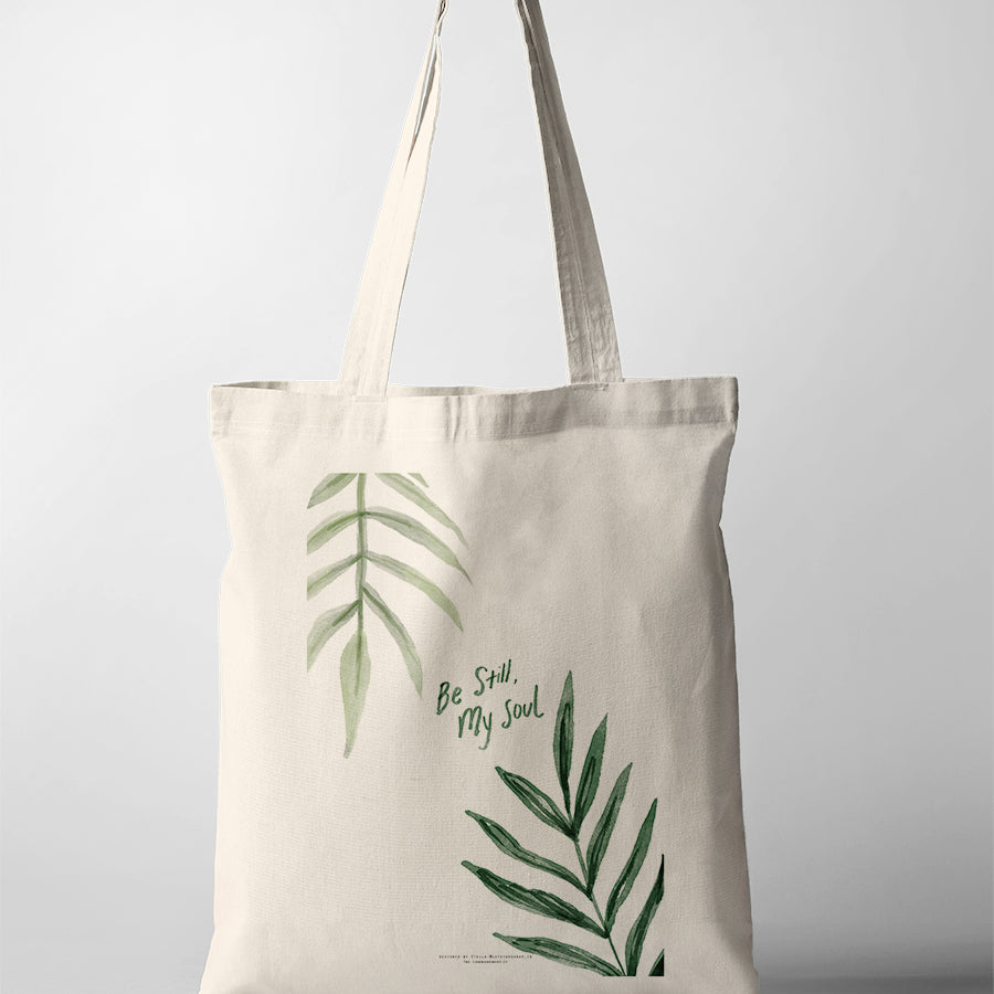 Christian tote bag featuring “Be Still, My Soul” with minimalist green botanical leaf illustrations