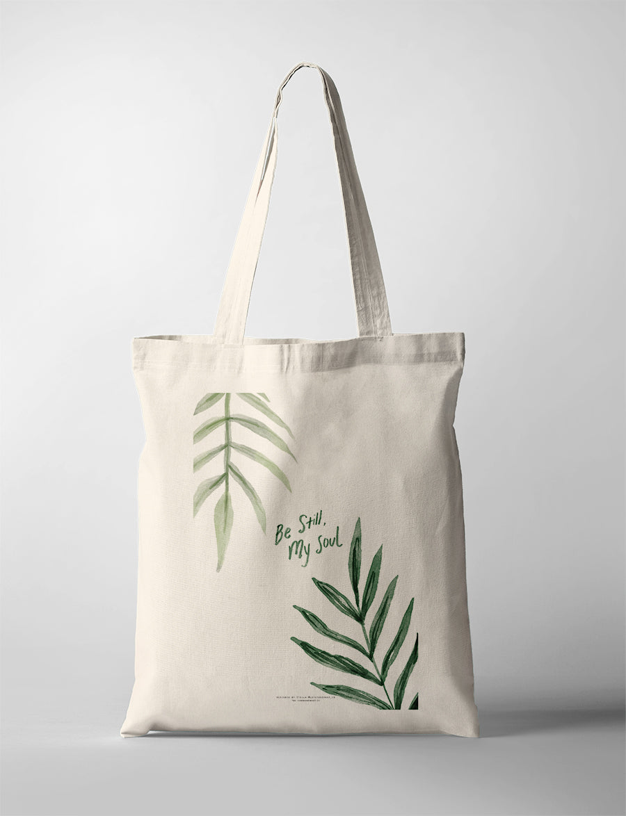 Christian tote bag featuring “Be Still, My Soul” with minimalist green botanical leaf illustrations