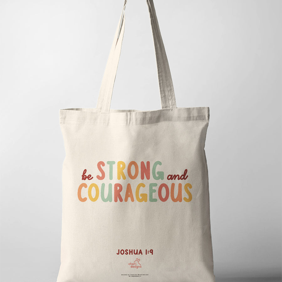 Christian canvas tote bag featuring “Be Strong and Courageous” Joshua 1:9 in colourful typography, faith-inspired tote bag collaboration with Chari Designs.