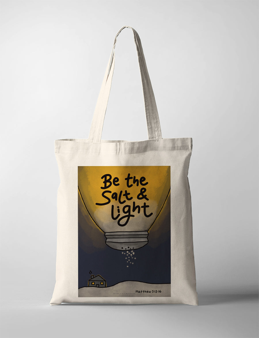 Cream canvas tote bag featuring “Be the Salt & Light – Matthew 5:13-16” with illustrated salt shaker and glowing light design, Christian inspirational tote bag.