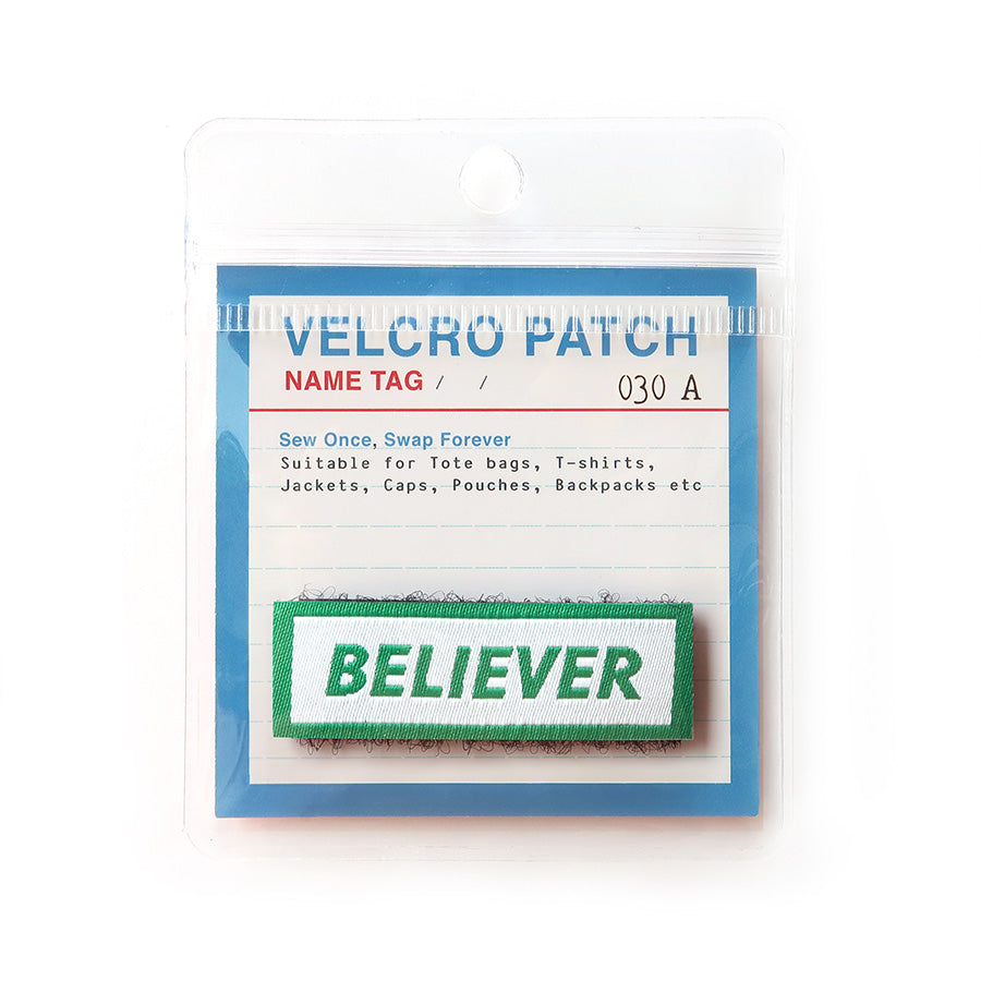 Velcro tag with the word 'Believer' in green text on a white background with a green border; a Christian-inspired accessory for clothing and bags