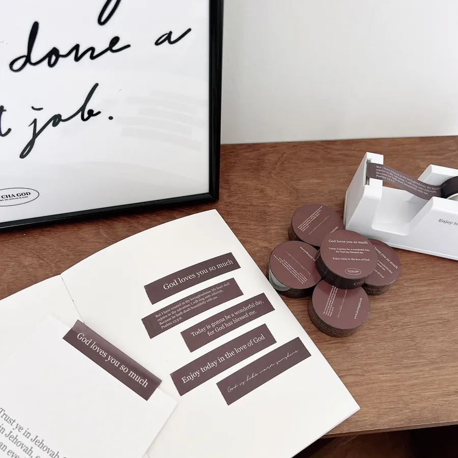 Faith-inspired washi tape rolls featuring Bible verses and uplifting quotes, shown with a notebook and dispenser, perfect for Christian journaling and gifts.