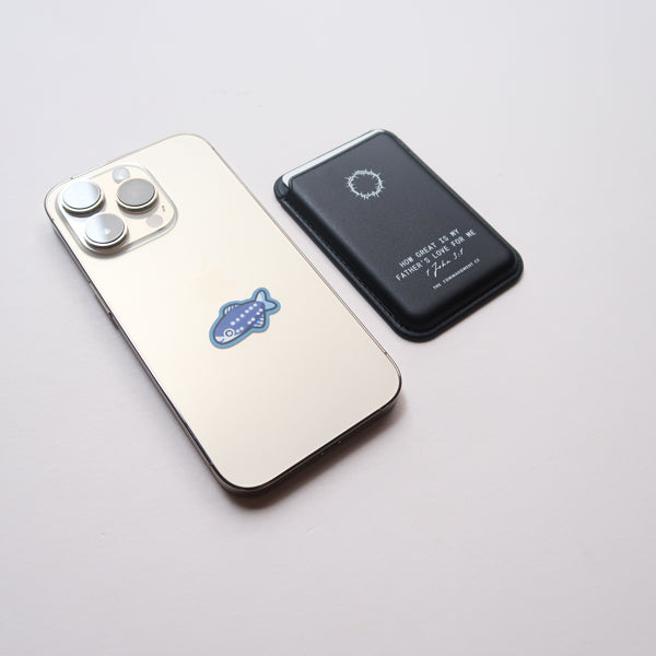 Black Leather Magsafe Wallet placed next to a mobile phone