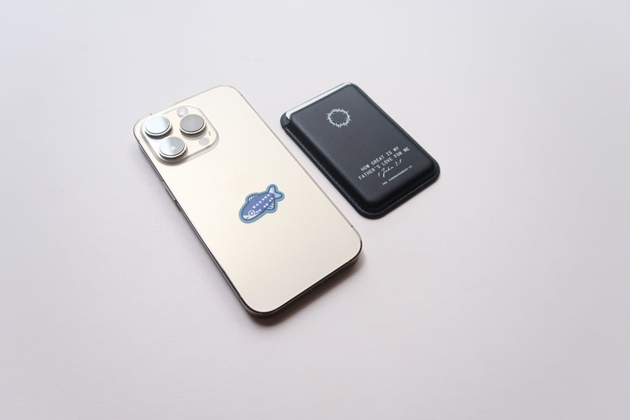 Black Leather Magsafe Wallet placed next to a mobile phone