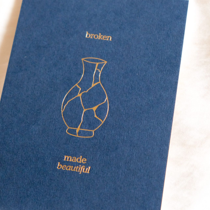 Minimalist letterpress art print with the words “broken” and “made beautiful” illustrated through a repaired ceramic vase.