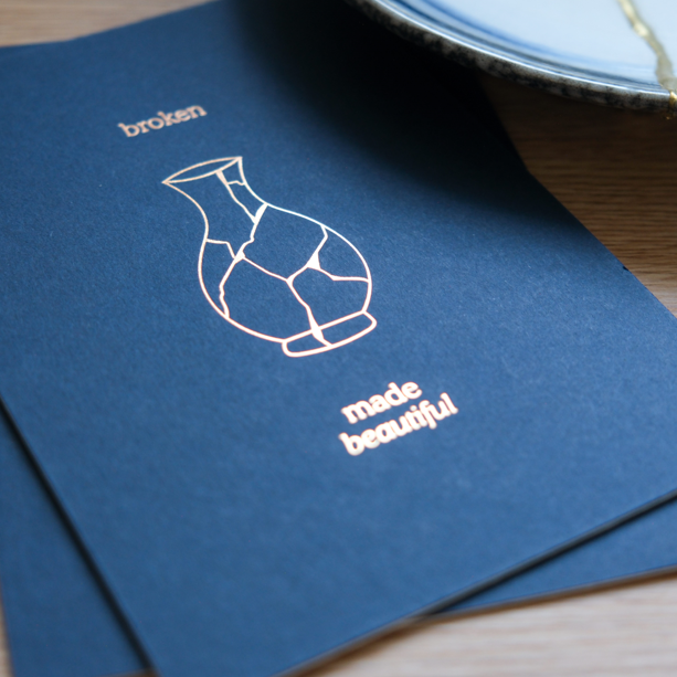 Elegant navy letterpress wall art featuring a kintsugi-style vase and the phrase “Broken Made Beautiful” in a clean, minimal design.