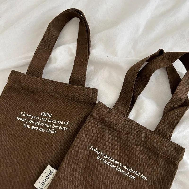 Two brown canvas drink carrier bags featuring Child I Love You and Wonderful Day faith-inspired text designs