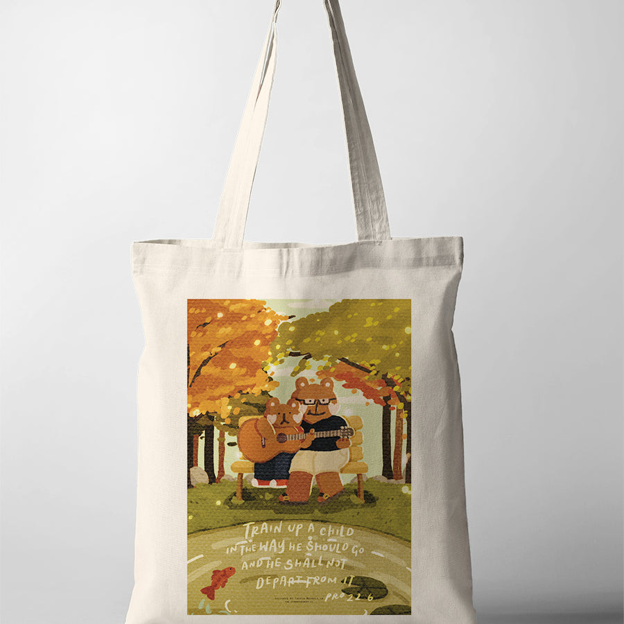 Natural canvas Christian tote bag featuring parent and child bears playing guitar beneath autumn trees with Proverbs 22:6.