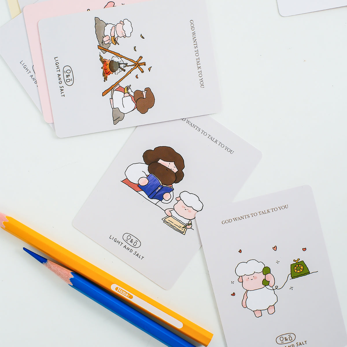 Christian mini encouragement cards featuring playful Jesus illustrations styled with pencils in a clean minimal flatlay setup