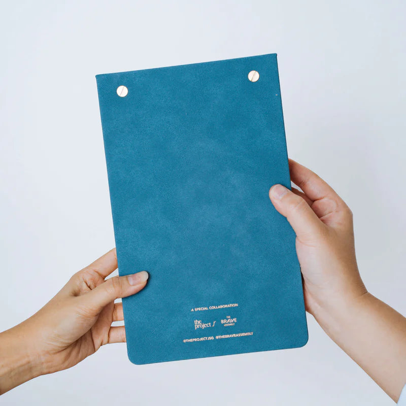 Back view of The Project J Christian notepad in blue, featuring a soft textured cover and special collaboration details, perfect for uplifting and faith-inspired daily planning.