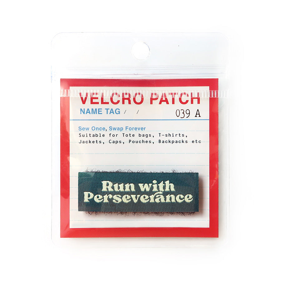 Velcro tag featuring the words 'Run with Perseverance' in cream text on a dark green background, ideal for Christian-themed clothing and accessories.