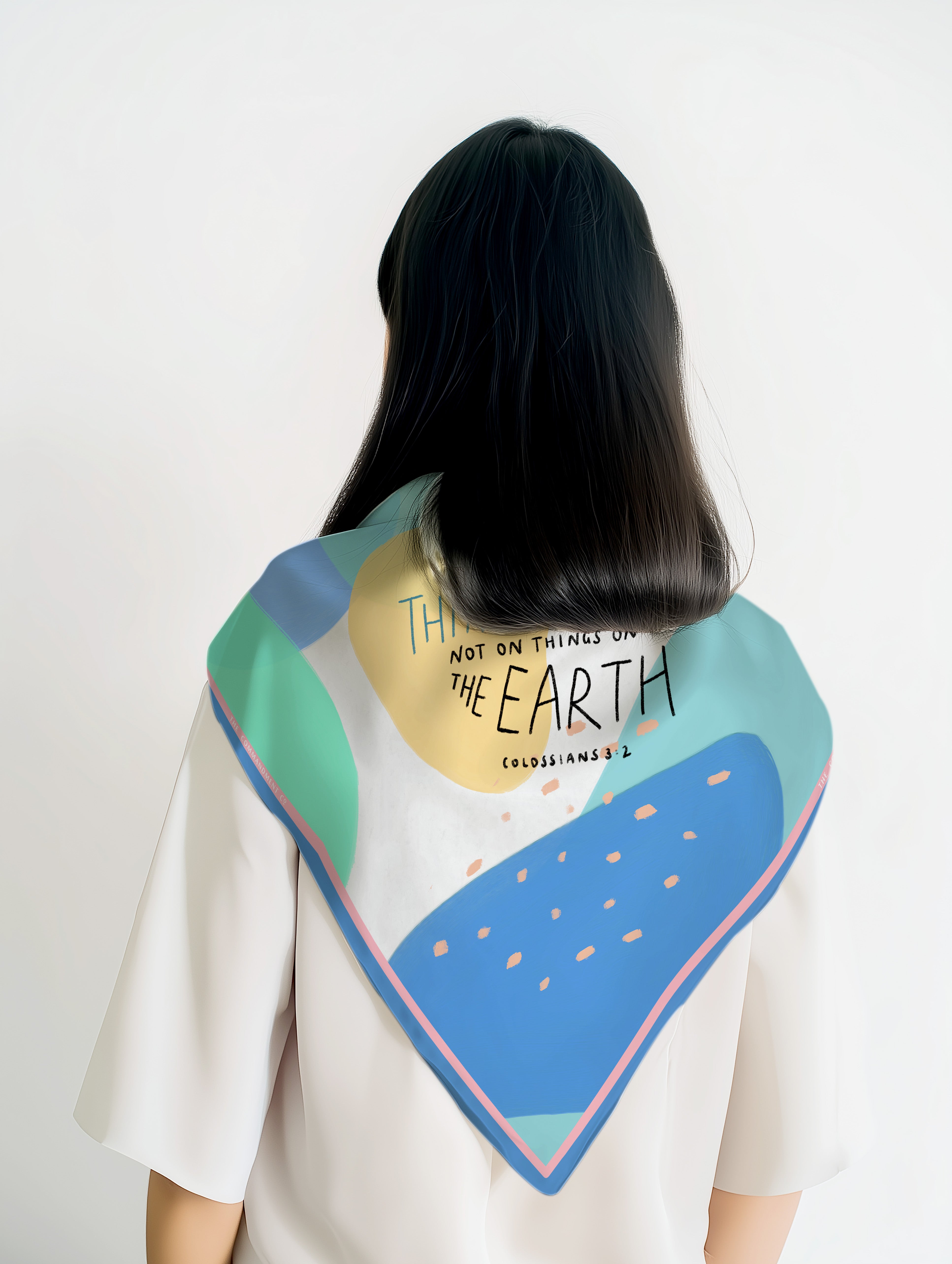 Back view of a model wearing a colorful abstract scarf featuring Colossians 3:2 “Set your mind on things above” in a modern Christian design by The Commandment Co.