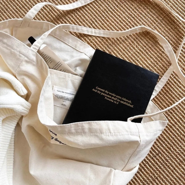Black Jin Cha God Commit Thy Works A5 notebook with gold foil Proverbs 16:3 cover styled inside a tote bag