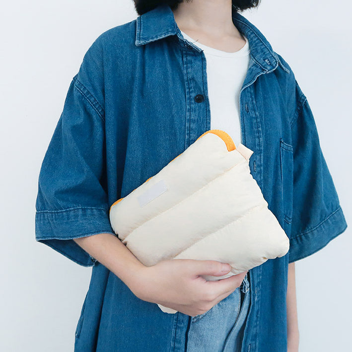 Person holding the soft Oat Pong Pong Bag against their side, highlighting its comfortable padding.