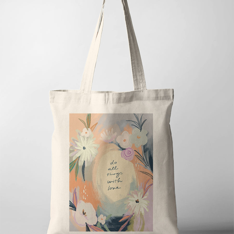 Christian canvas tote bag featuring pastel floral artwork with the phrase “Do All Things With Love,” faith-inspired illustration collaboration with letstakeanap_id.