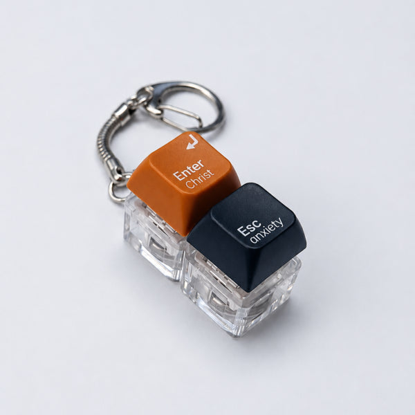 Enter Christ Esc anxiety double light-up keycap keychain in orange and black on a white background