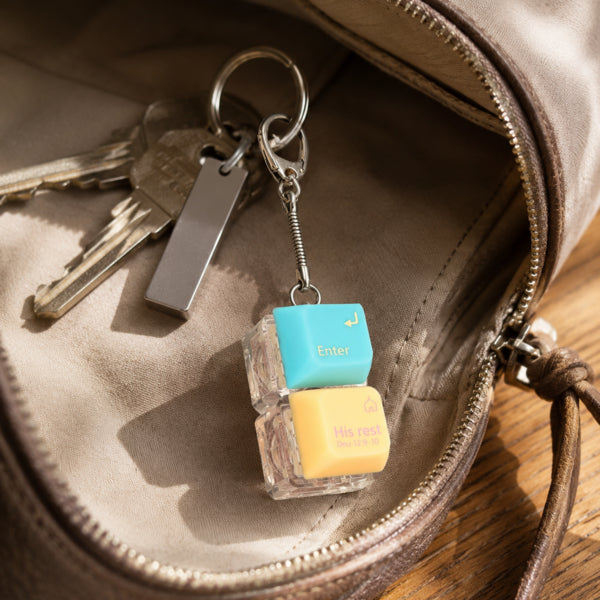 Enter His Rest double keycap keychain beside keys inside a brown bag