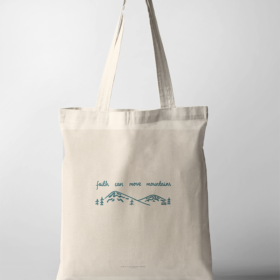 Minimalist "faith can move mountains" tote bag, featuring simple blue line art of mountains and trees, inspiring Christian faith and simple happiness.