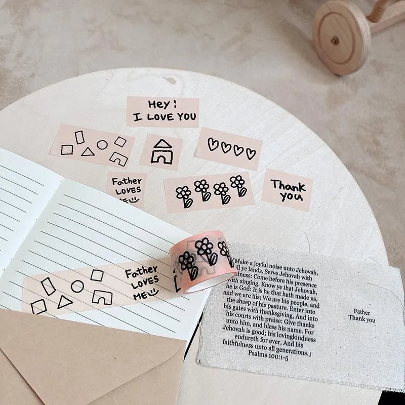 Hand-drawn Father Loves Me washi tape featuring Christian phrases, flowers and playful illustrations on a journal and Bible-inspired fabric