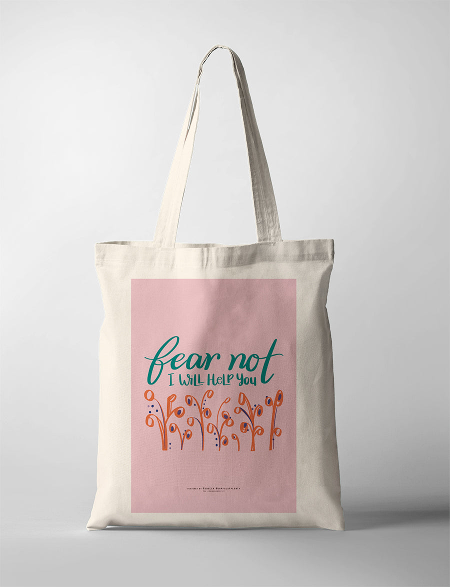 Pink Christian tote bag with hand lettering ‘Fear Not, I Will Help You’ and floral design inspired by Isaiah 41:13 promise of God’s help.