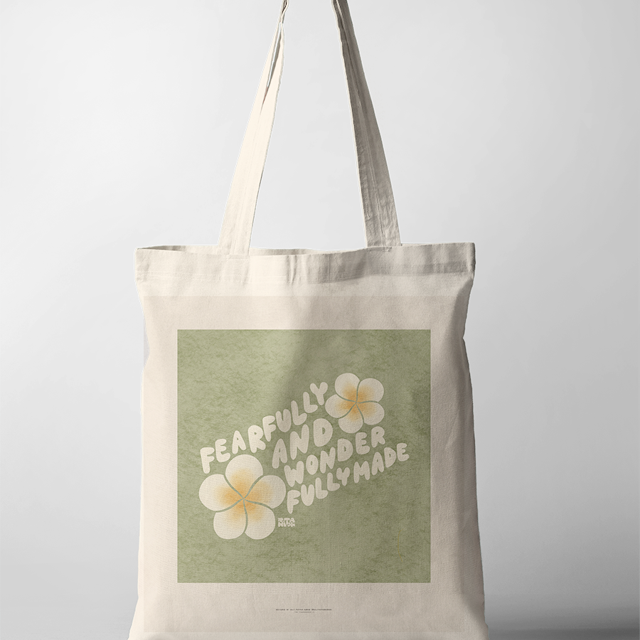 Encouraging "Fearfully and wonderfully made" tote bag, featuring bold white lettering and soft yellow flowers on a green background, celebrating Christian identity and simple happiness.