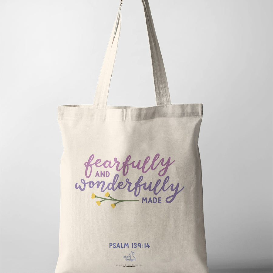 Christian canvas tote bag featuring “Fearfully and Wonderfully Made” Psalm 139:14 in soft purple typography with floral illustration, collaboration with Chari Designs.