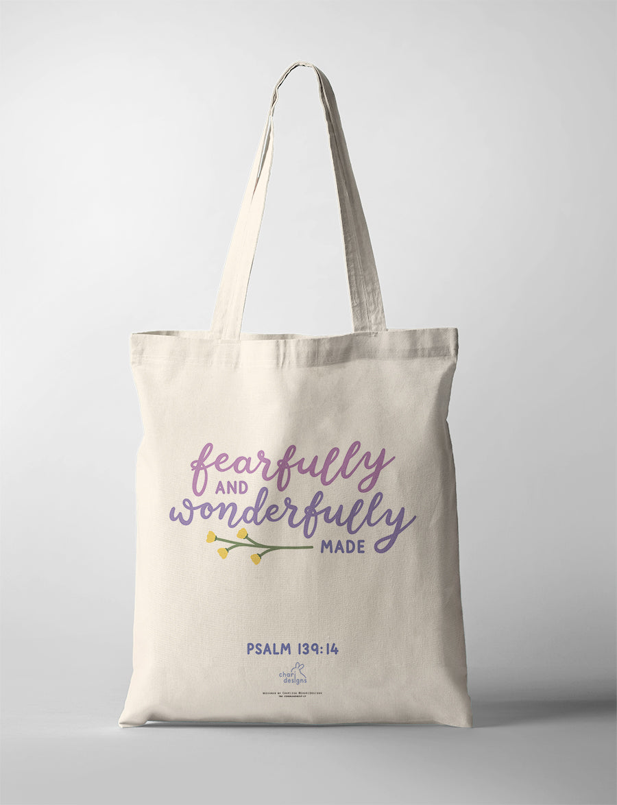 Christian canvas tote bag featuring “Fearfully and Wonderfully Made” Psalm 139:14 in soft purple typography with floral illustration, collaboration with Chari Designs.