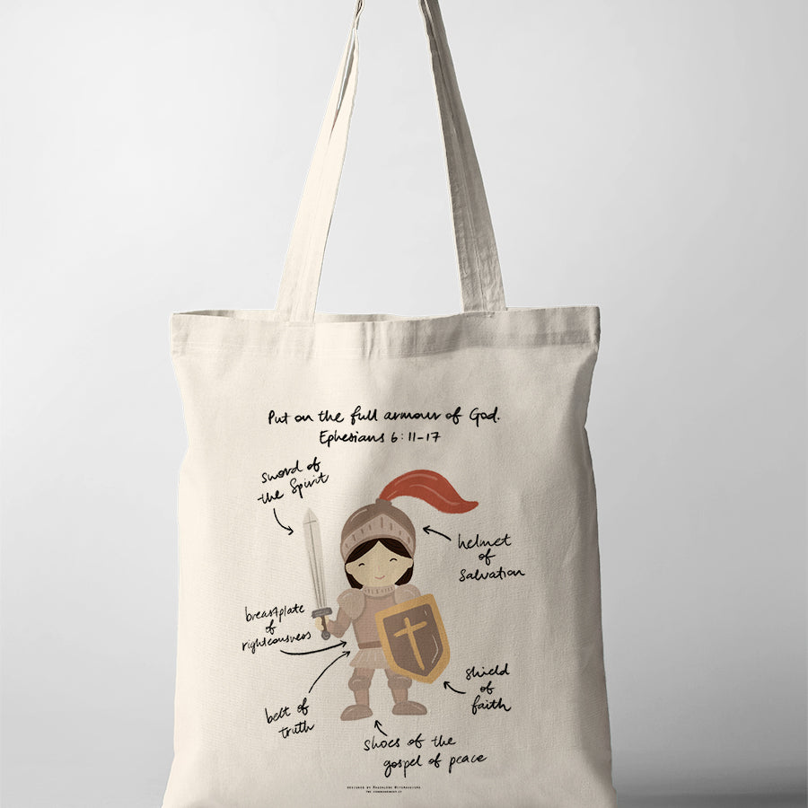 Christian kids tote bag featuring a girl in the full armour of God with labelled pieces from Ephesians 6:11–17, including the sword of the Spirit, helmet of salvation, shield of faith, belt of truth, breastplate of righteousness, and shoes of the gospel of peace.