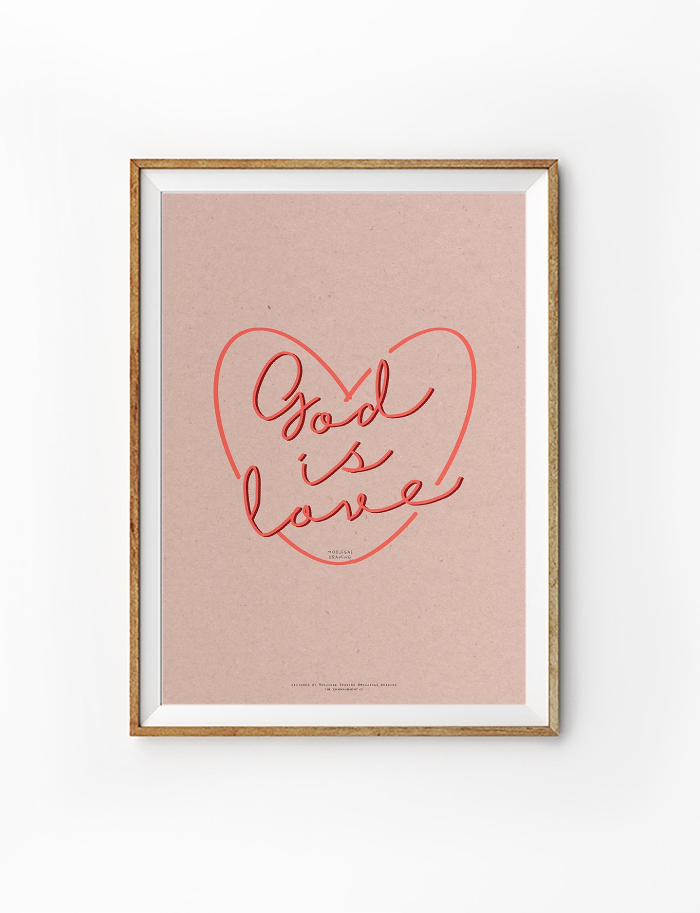 Christian wall art poster featuring hand-lettered “God is Love” inside a heart illustration on a soft pink background, designed by Moojigae Drawing in collaboration with The Commandment Co.
