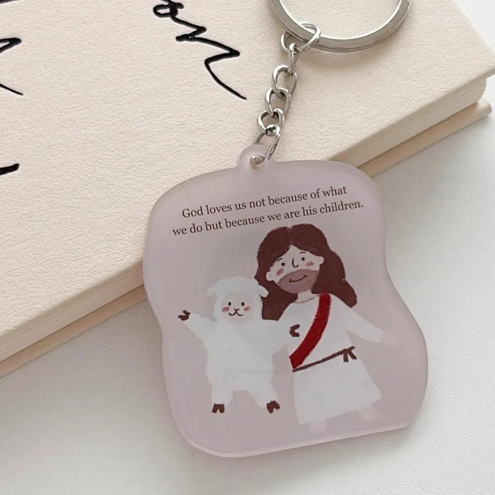 Close-up of the God Loves Us acrylic keychain featuring Jesus with a sheep and the message about being loved as God’s children
